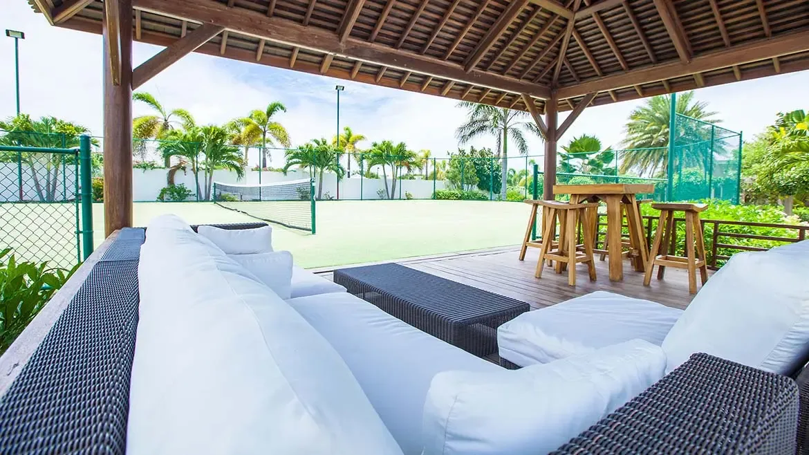 Rectangular pool and white terrace with a red accent wall and ocean views.