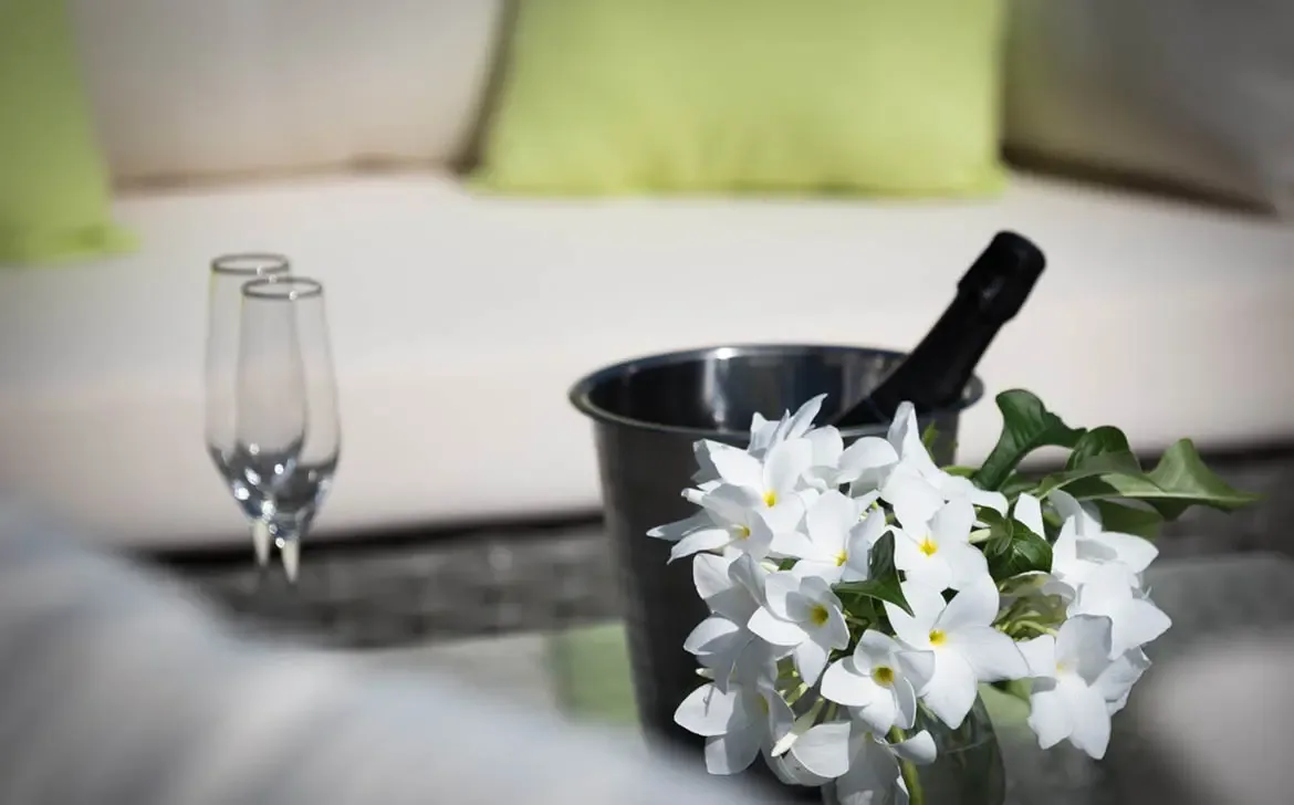 A chilled bottle of champagne and fragrant white blooms set the stage for a romantic afternoon on the sun-drenched terrace of Villa Gem Palm Springs.