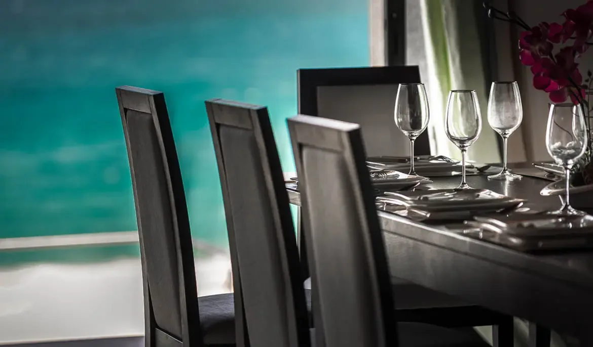 Experience elegant indoor dining with a sophisticated setting and breathtaking glimpses of the turquoise sea.