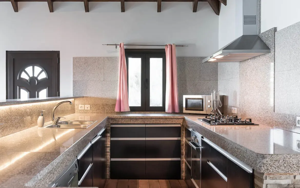 The sleek, gourmet kitchen features premium granite countertops and modern appliances, perfectly suited for crafting island-inspired culinary delights.