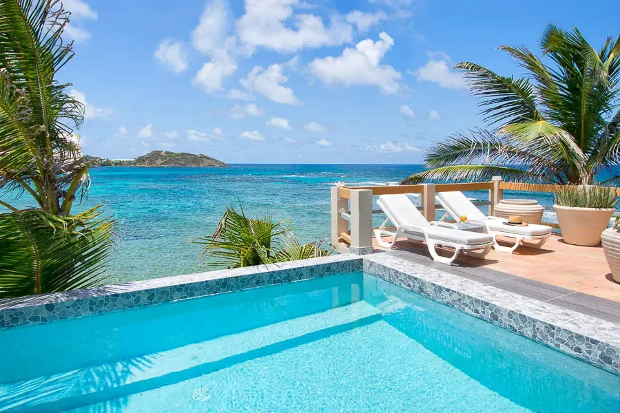 Crystal-clear waters, mosaic-tiled pool, and the Caribbean Sea beyond — your private paradise.