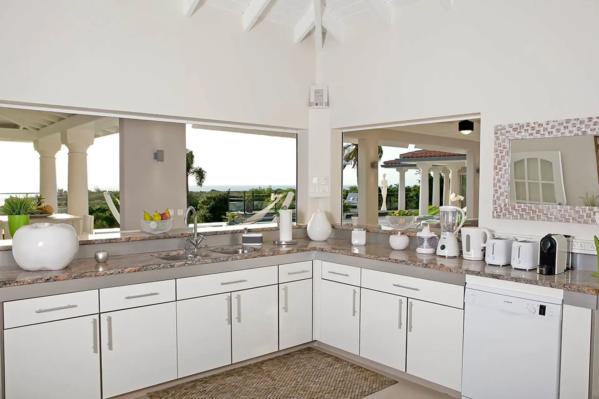 Open kitchen flowing to terrace with sea views.