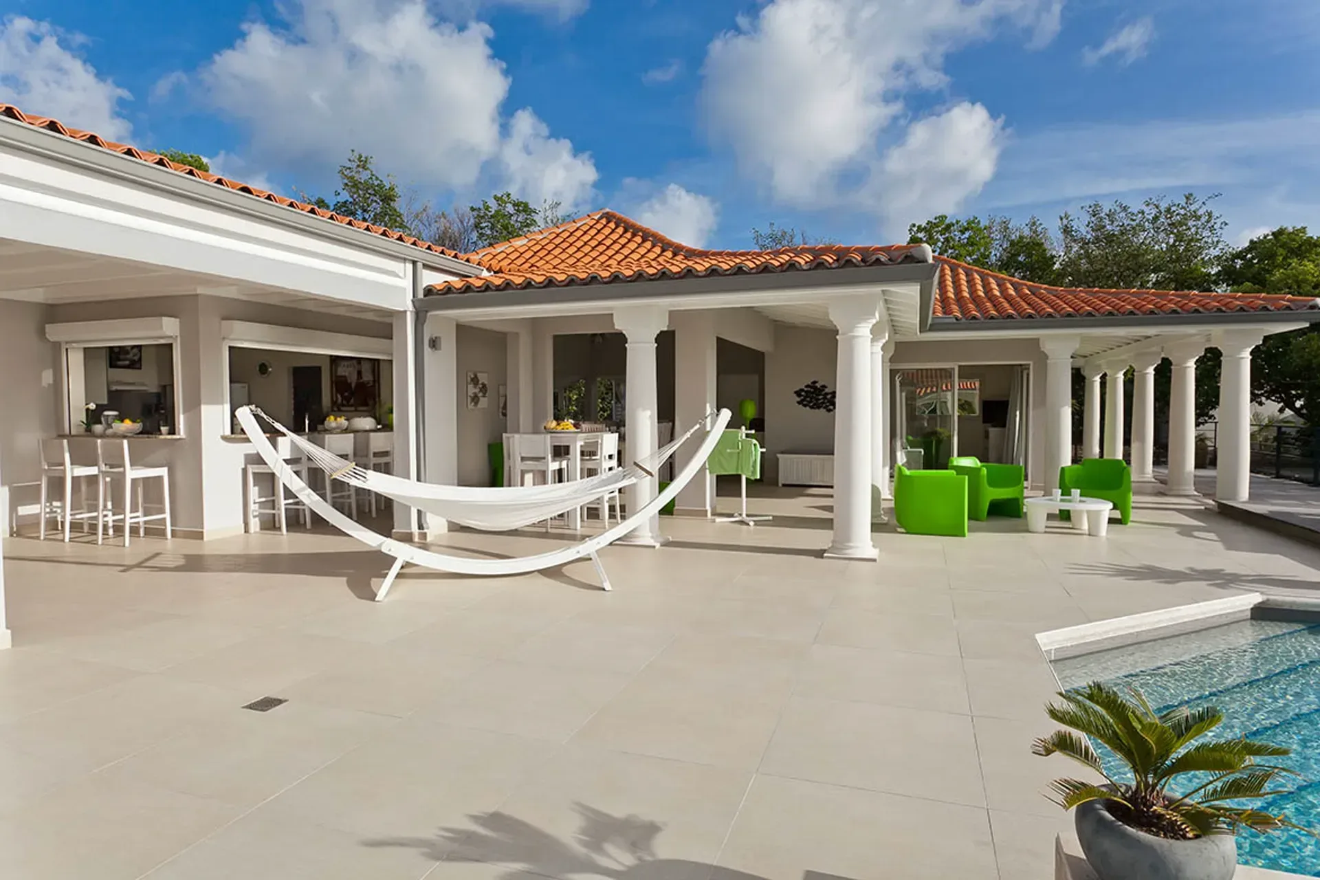 Covered terrace with hammock and outdoor bar area.